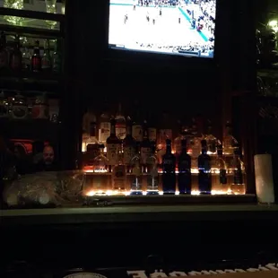 a bar with a television and liquor bottles