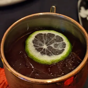 a drink in a copper mug with a slice of lime