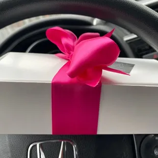 a gift wrapped in a pink ribbon