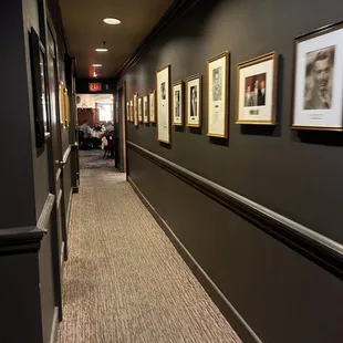 a long hallway with framed photographs