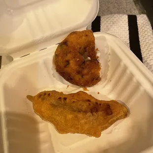 two fried food items in a styrofoam container