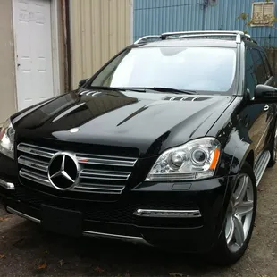 a black mercedes suv parked in front of a building