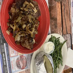 Ribeye steak with mushrooms and onions, baked potato and green beans