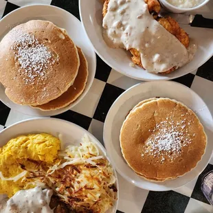 Chicken fried steak, grits, and eggs on top plate.  Country fried steak, eggs, and hashbrowns. Regular pancakes.