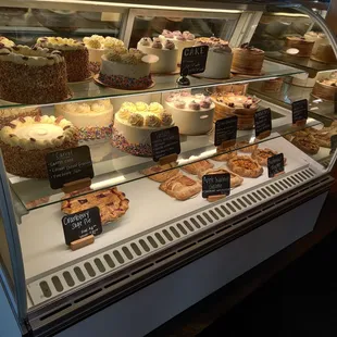 a display case filled with cakes and pastries