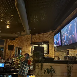 a bar with people watching tvs