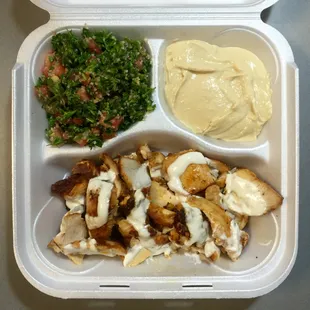 Crispy chicken shawarma drizzled with a light garlic sauce and sides of tabouli and hummus.