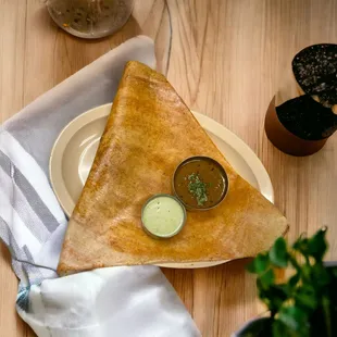 a plate of food and a napkin on a wooden table