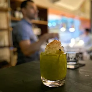 a man sitting at a bar with a drink in front of him