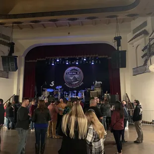 a crowd of people standing in front of a stage