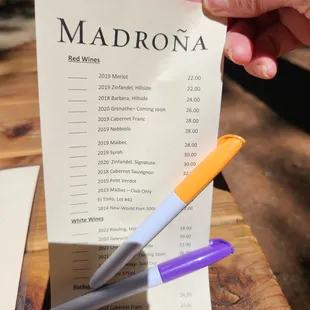 a hand holding a pen and a menu