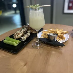 White linen cocktail with wings and fries