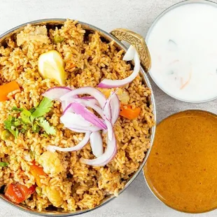 a bowl of rice with onions, carrots, onions, and yogurt