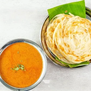 a plate of roti and a bowl of tomato soup