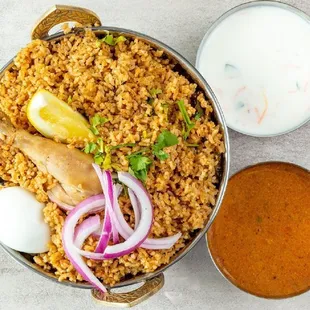 a bowl of rice with chicken, onions, and yogurt