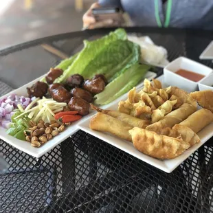 Issan Pork sausage with sticky rice  on the left, appetizer sampler on the right.