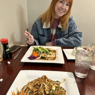 a woman sitting at a table with a plate of food