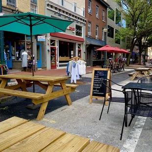 tables and umbrellas on the sidewalk