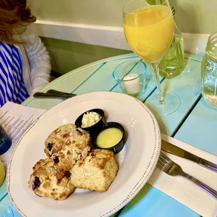 a plate of scones and a glass of orange juice