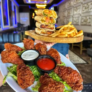 a plate of fried chicken wings and fries