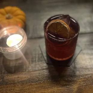 a glass of wine with a slice of orange