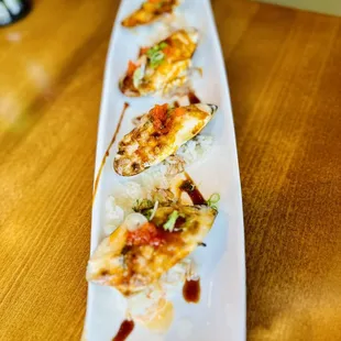 a long rectangular white plate with shrimp