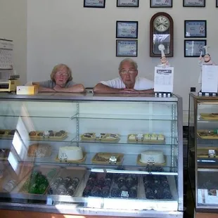 Magee and Hubby standing behind one of their cases 2013. You can see the Transparent Tarts and Pies in the right case.