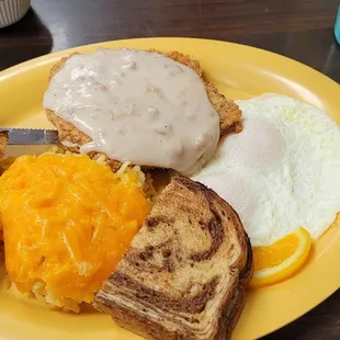 Country fried steak and eggs with rye toast and hashbrown casserole.