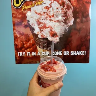 a hand holding a cup of ice cream