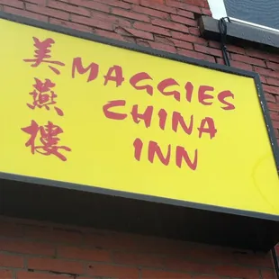 a yellow sign on a brick building