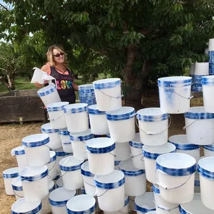 a woman standing in front of a pile of buckets