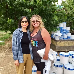 two women standing in front of a pile of buckets