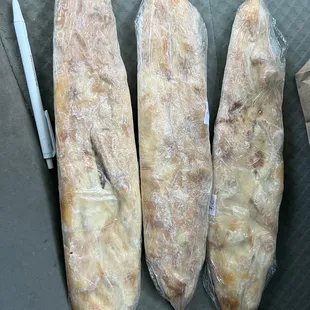 three baguets wrapped in plastic