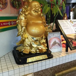 a gold statue of a laughing buddha