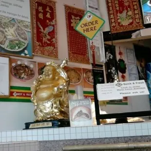 a restaurant counter with a gold statue