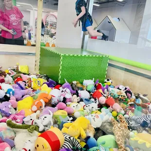 a child jumping over a pile of stuffed animals