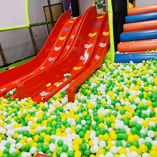 a child playing in a ball pit