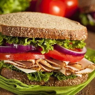 a turkey sandwich with lettuce and tomatoes