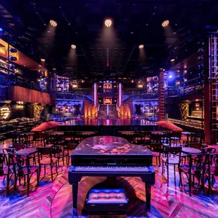 a brightly lit bar with a piano in the middle of the room