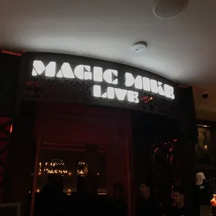 a neon sign above a bar