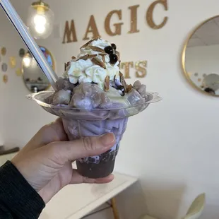 a hand holding a cup of ice cream