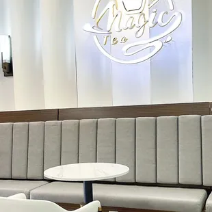 a table and chairs in front of a neon sign