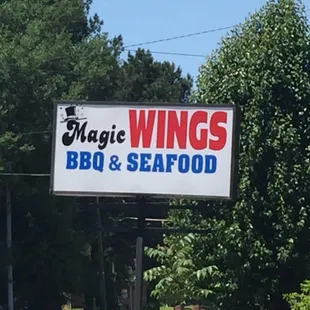 a sign for magic wings bbq and seafood