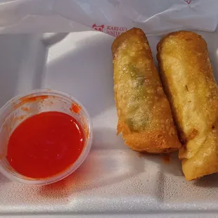 two fried spring rolls and a dipping sauce