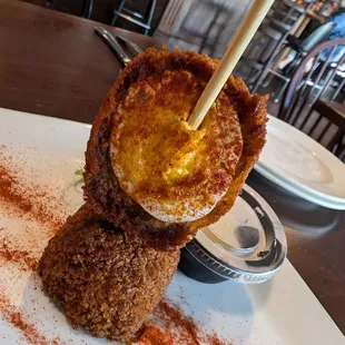Scotch egg .. boiled egg wrapped on sausage and breadcrumbs fried with paprika