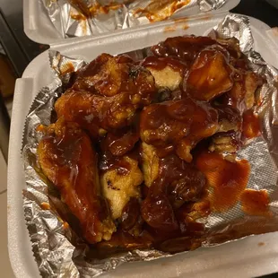 a tray of chicken wings covered in bbq sauce