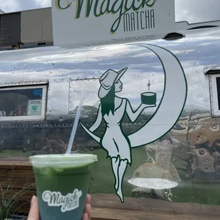 a hand holding a cup of matcha