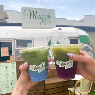 two people holding cups of matcha