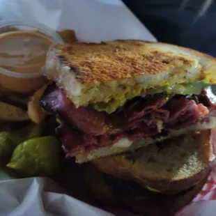 Grilled Pastrami sandwich with seasoned steak fries.