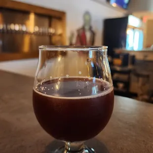 a glass of beer on a bar